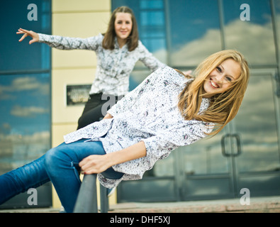 Zwei junge Frauen auf Geländer ausgeglichen Stockfoto