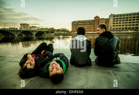 Vier Freunde sitzen Fluss, zwei liegend, Russland Stockfoto