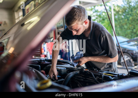 Mechaniker arbeiten am Fahrzeug mit offener Motorhaube Stockfoto