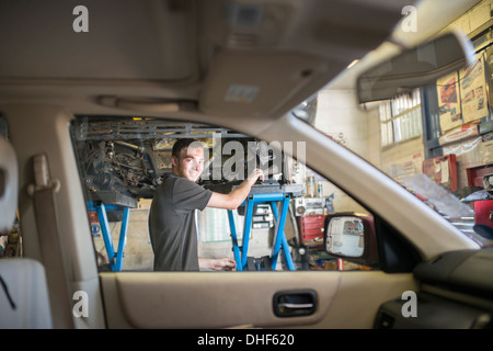 Mechaniker, die lächelnd in Richtung Kamera durch Autofenster Stockfoto