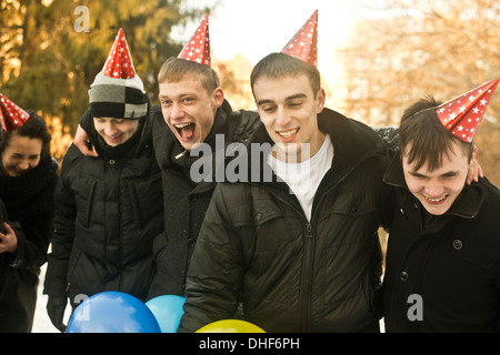 Gruppe junger Freunde mit dem tragen Partyhüte Stockfoto