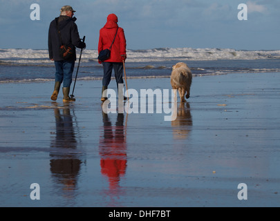 Reifen Sie paar zu Fuß am Strand entlang in Winter, Bude, Cornwall, UK Stockfoto