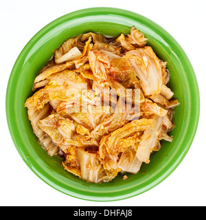 fermentierter Chinakohl mit Knoblauch und Zwiebeln - eine Tradition koreanischen Kimchi Schale in eine kleine Keramikschale, isoliert auf weiss Stockfoto