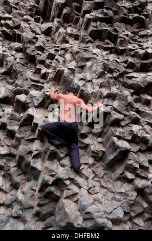 Ein Mann klettert barfuß in Los Ladrillos eine Basaltwand aus Felsen, die durch vulkanische Aktivität in der Provinz Boquete Republik Panama verursacht wird Stockfoto