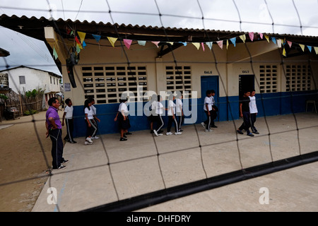 Schulkinder in Carti Sugtupu Island Village durch Guna Eingeborenen als Kuna in der "Comarca" (Region) der Guna Yala im Archipel von San Blas Blas Inseln im Nordosten von Panama mit Blick auf das Karibische Meer bekannt gegeben. Stockfoto