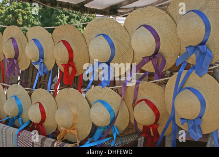 Mädchen Bändern Stroh Sonnenhüte an einer Wäscheleine hängen Stockfoto