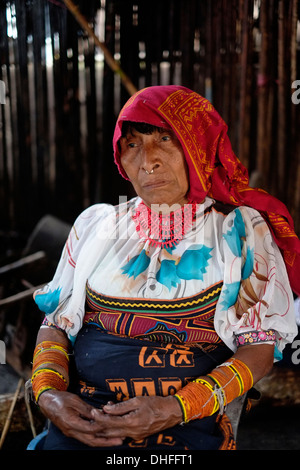 Eine ältere Frau aus dem Guna Menschen tragen traditionelle handgefertigte Mula Kleid in Carti Sugtupu Island Village durch Guna Eingeborenen als Kuna in der "Comarca" (Region) der Guna Yala im Archipel von San Blas Blas Inseln im Nordosten von Panama mit Blick auf das Karibische Meer bekannt gegeben. Stockfoto