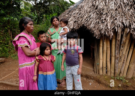 Einheimische Frauen und Kinder der ethnischen Gruppe der Ngabe & Bugle stehen vor ihrer Hütte in der Region Comarca Quebrado, Guabo Reservat in der Provinz Chiriqui Republik Panama Stockfoto