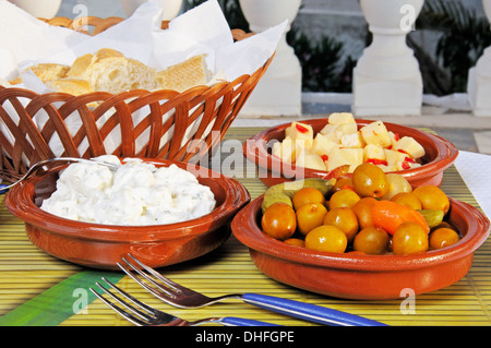 Auswahl an Tapas - von links nach rechts: Kartoffelsalat, grüne Olive Cocktail, Cubed Manchego Käse in Olivenöl mit Chili. Stockfoto