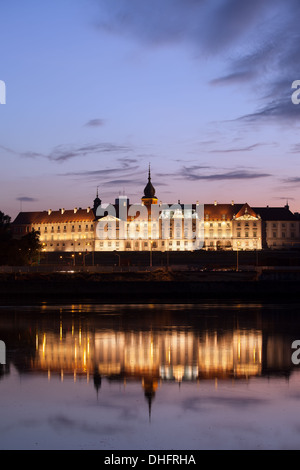 Königsschloss beleuchtet in der Dämmerung mit Reflexionen über das Wasser des Flusses Vistula in der alten Stadt von Warschau, Polen. Stockfoto