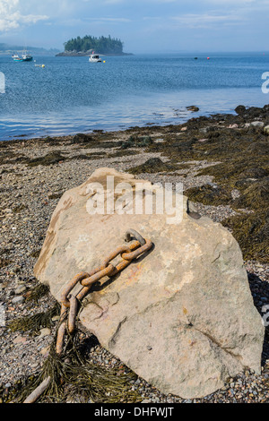 Eine Ankerkette befestigt an einem großen Felsbrocken liegt auf einem auf felsigen Küstenstreifen an Lubec Maine. Stockfoto