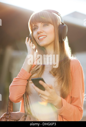 Junge schöne Mädchen anhören von MP3-Player auf der Straße Stockfoto