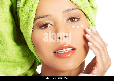 Schöne Frau das Gesicht mit einer Creme unter Auge. Isoliert auf weiss. Stockfoto