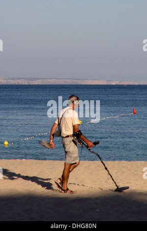 Ein Mann verwendet einen Metalldetektor am Strand von Palmanova Mallorca Spanien Stockfoto