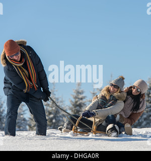 Freunde, die Spaß im Schnee mit dem Schlitten sonnigen Winter Stockfoto