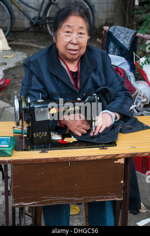 Näherin, die Arbeit in einer Seitengasse in Chengdu, Sichuan, China Stockfoto