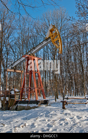 Ölpumpe arbeitet auf Winter-Wald-Hintergrund Stockfoto