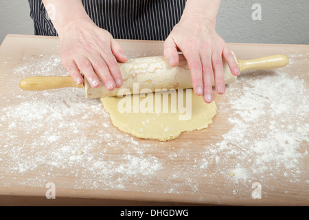 Teig ausrollen auf einer bemehlten Arbeitsfläche Stockfoto