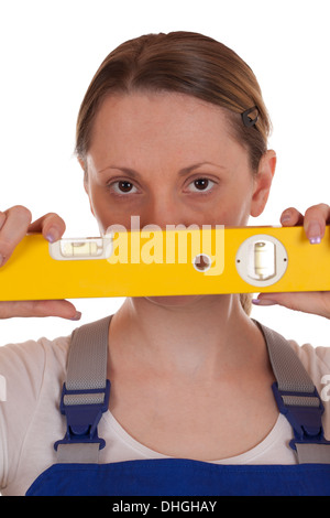 Junge Frau mit einer Wasserwaage in der Hand, isoliert auf weiss Stockfoto
