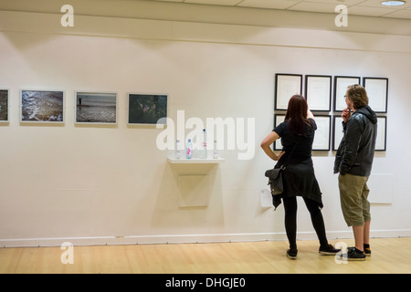 Junges Paar Blick auf Objekt angezeigt bei einer Kunstausstellung, Bath, Somerset, Großbritannien Stockfoto