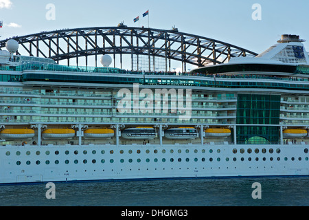 Royal Caribbean Cruise Liner, Radiance of the Seas fährt Sydney in der Abenddämmerung, der berühmten Sydney Harbour Bridge im Hintergrund. Stockfoto