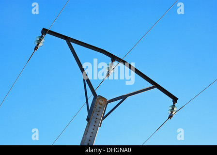 Mittelspannungs-Metall-Turm mit grünem Glas Isolatoren Hintergrundbeleuchtung auf blauen Himmel Stockfoto