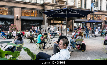 Fußgänger genießen Sitzbereich auf Abschnitt für den Verkehr vor Eingang zu Macy's Flagship-Store Manhattan Broadway Stockfoto