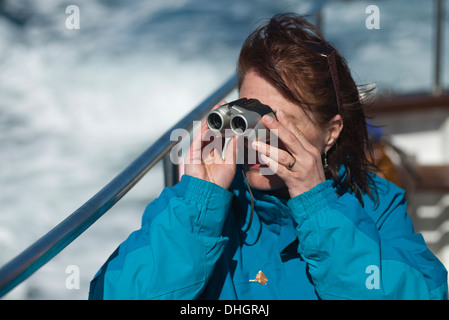 Frau auf eine Genuss-Kreuzfahrt durch ein Fernglas schauen Stockfoto
