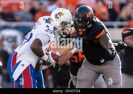 Stillwater, Oklahoma, USA. 9. November 2013. 9. November 2103: Oklahoma State Cowboys defensive Tackle Calvin Barnett (99) befasst sich mit Kansas Jayhawks Runningback James Sims (29) während der NCAA Football-Spiel zwischen die Kansas Jayhawks und die Oklahoma State Cowboys im Boone Pickens Stadium in Stillwater, OK. Die Cowboys besiegte die Jayhawks 42-6. © Csm/Alamy Live-Nachrichten Stockfoto