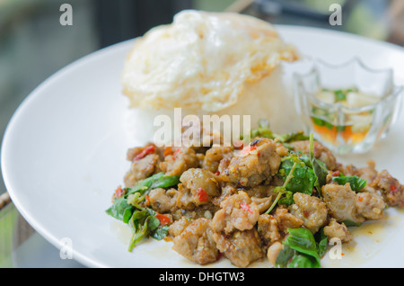 Rühren Sie gebratenes gehacktes Schweinefleisch mit Chili, Basilikum serviert mit Reis und Spiegelei Stockfoto