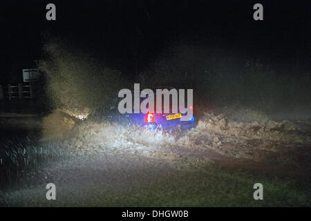 Helston nach Porthleven Rd., Cornwall, UK. 11. November 2013. Ein Auto fährt langsam durch Hochwasser, Starkregen und verstopften Abflüssen zurückzuführen. Bob Sharples/Alamy Stockfoto