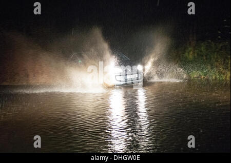 Helston nach Porthleven Rd., Cornwall, UK. 11. November 2013. Ein Auto fährt langsam durch Hochwasser, Starkregen und verstopften Abflüssen zurückzuführen. Bob Sharples/Alamy Stockfoto