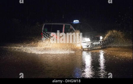 Helston nach Porthleven Rd., Cornwall, UK. 11. November 2013. Taxi fährt langsam durch Hochwasser, Starkregen und verstopften Abflüssen zurückzuführen. Bob Sharples/Alamy Stockfoto