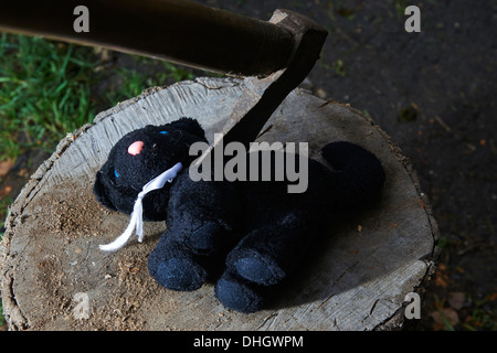 Ausführung - Mord an Kind Kuscheltier schwarze Katze mit einer Axt Stockfoto