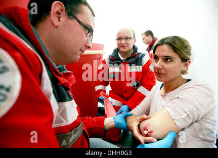 Achim Horneff (L) und Manuel Kamp Freiwilligen das Deutsche Rote Kreuz (DRK) Beihilfen gewähren "verletzten" Anja Jähne (R) während einer Übung in Darmstadt-Arheilgen, 22. Oktober 2013. Die Freiwilligen der Darmstadt-Praxis für den Notfall regelmäßig - und manchmal für einen Wettbewerb. Foto: ANDRÉ HIRTZ Stockfoto