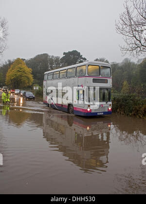 Helston nach Porthleven Rd., Cornwall, UK. 11. November 2013. Workman Kampf, verstopfte Abflüssen zu löschen verursacht Überschwemmungen im Laufe der Schulbus. Bob Sharples/Alamy Stockfoto