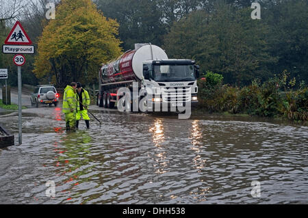 Helston nach Porthleven Rd., Cornwall, UK. 11. November 2013. Workman Kampf, verstopfte Abflüssen zu löschen die Überschwemmungen verursacht. Stockfoto