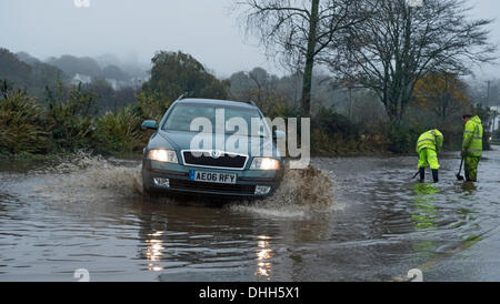 Helston nach Porthleven Rd., Cornwall, UK. 11. November 2013. Workman Kampf, verstopfte Abflüssen zu löschen die Überschwemmungen verursacht Stockfoto