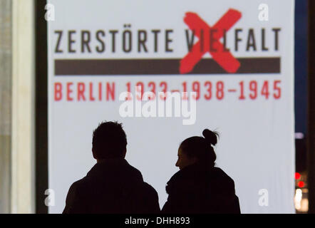 Berlin, Deutschland. 10. November 2013. Eine Silhouette paar geht vorbei an einer Projektion auf dem Brandenburger Tor in Berlin, Deutschland, 10. November 2013. Das Themenjahr "Vielfalt - zerstört 1933-1938 - 1945" mit der Projektion von Videos endet funktioniert durch Jugendliche, Porträts der verfolgten Künstler während des NS-Regimes, Gespräche mit Zeitzeugen und Konzerte am Pariser Platz in Berlin, Deutschland, 10. November 2013. Foto: Florian Schuh/Dpa/Alamy Live News Stockfoto