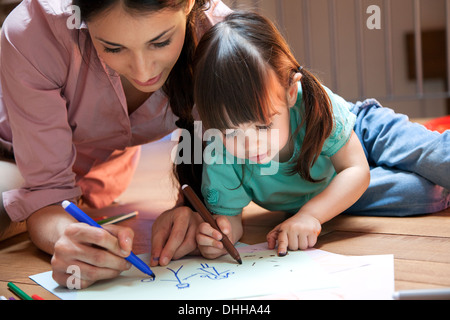 Mutter und Tochter auf Boden zeichnen Stockfoto