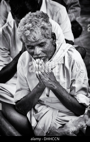 Alte indische im Gebet während der Wartezeit am Sri Sathya Sai Baba mobile aufsuchende Hospital. Andhra Pradesh, Indien.  Schwarz und weiß. Stockfoto