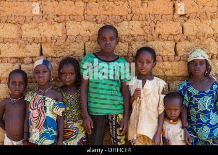 Kajuru, Nigeria. 31. Oktober 2013. Fulani-Kinder posieren an der Wand eines traditionellen Hauses. Fulanis sind traditionell nomadischen Leute, Rinder, Ziegen und Schafe hüten. Sie sind eines der größten nomadischen Volksgruppen in der Welt, über mehrere Gebiete verbreitet. Die Fulani folgen einen Verhaltenskodex bekannt als Pulaaku, bestehend aus den Qualitäten von Geduld, Selbstbeherrschung, Disziplin, Klugheit, Bescheidenheit, Achtung vor anderen Menschen (einschließlich Feinde), Weisheit, Eigenverantwortung, Gastfreundschaft, Mut und harte Arbeit. Zsolt Repasy/ZUMAPRESS.com/Alamy © Live-Nachrichten Stockfoto