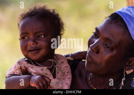 Kajuru, Nigeria. 31. Oktober 2013. Fulbe-Frau mit ihrem Baby. Die Frau trägt traditionelle Stammes-Spuren im Gesicht. Fulanis sind traditionell nomadischen Leute, Rinder, Ziegen und Schafe hüten. Sie sind eines der größten nomadischen Volksgruppen in der Welt, über mehrere Gebiete verbreitet. Die Fulani folgen einen Verhaltenskodex bekannt als Pulaaku, bestehend aus den Qualitäten von Geduld, Selbstbeherrschung, Disziplin, Klugheit, Bescheidenheit, Achtung vor anderen Menschen (einschließlich Feinde), Weisheit, Eigenverantwortung, Gastfreundschaft, Mut und harte Arbeit. Zsolt Repasy/ZUMAPRESS.com/Alamy © Live-Nachrichten Stockfoto