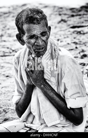 Alte indische im Gebet während der Wartezeit am Sri Sathya Sai Baba mobile aufsuchende Hospital. Andhra Pradesh, Indien. Schwarz und weiß. Stockfoto