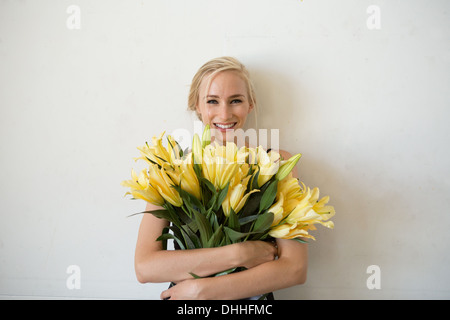 Porträt der jungen Frau mit gelber Blumenstrauß Stockfoto