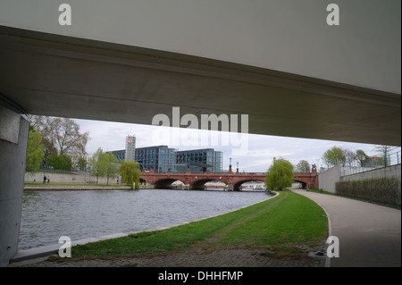 Grauen Himmelsblick vom Wanderweg unter Fußgängerbrücke im neuen Bundeskanzleramt, rotem Sandstein Moltebrucke Überquerung Fluss Spree, Berlin Stockfoto