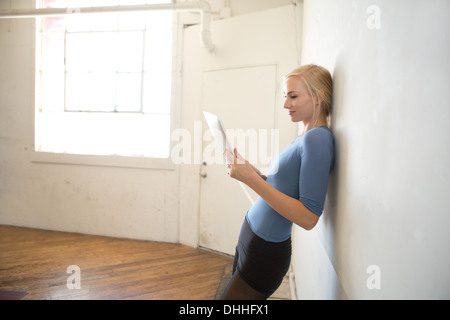 Tänzerin mit digital-Tablette Wand gelehnt Stockfoto