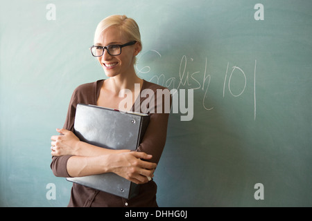 Lehrer halten Ringbuch von blackboard Stockfoto