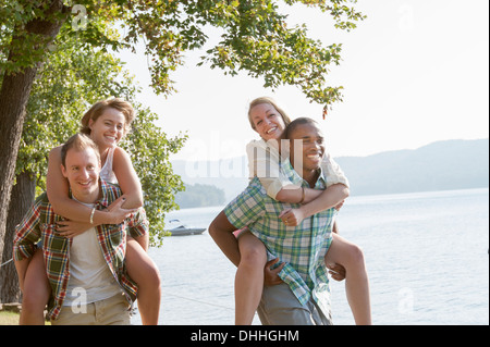 Junge Männer, Frauen, die Piggy backs Stockfoto