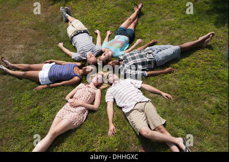 Freunde, die liegen auf dem Rasen eingeschlafen im Kreis Stockfoto